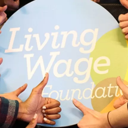 Thumbs around Living Wage logo