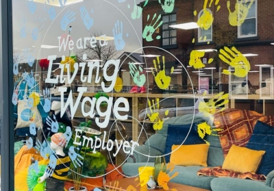 Renewal NW's window, with the Living Wage logo and handprints