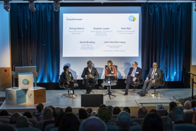 5 people sitting on a stage talking to an audience