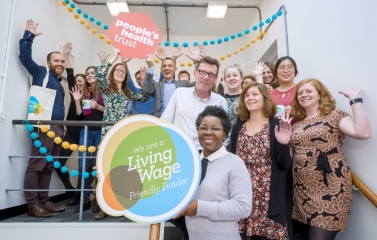 People's Health Trust team smiling and holding up a Living Wage Foundation foamboard