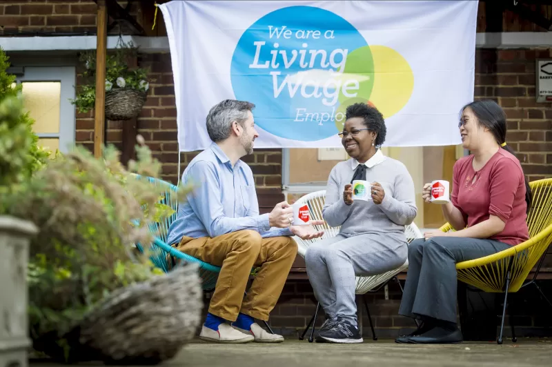 Group talking sat down in front of Living Wage Funder banner